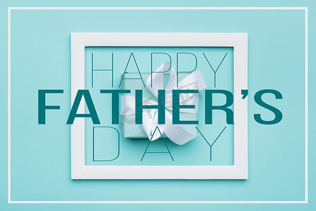快乐父亲节贺卡摄影照片_快乐的父亲节柔和的糖果颜色背景。平躺极简式贺卡与相框和美丽的礼物.