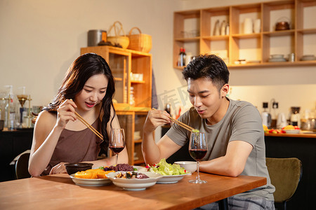 情侣吃饭摄影照片_年轻夫妇在家用餐