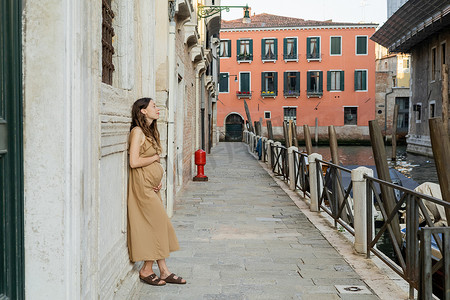 Side view of pregnant woman standing near old building on street in Venice 