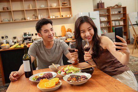 情侣吃饭摄影照片_年轻夫妇在家用餐