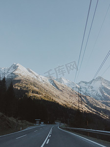 在一条穿过高山的街道上行驶, 冬天有雪, 阳光明媚, 景色宜人