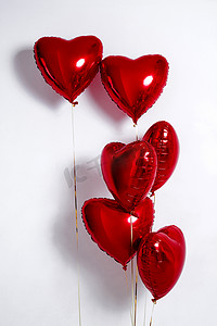 一套空气气球。一束红色的心形铝箔气球,在白色背景上隔离.爱。假日庆祝。情人节派对装饰。金属红心气球
