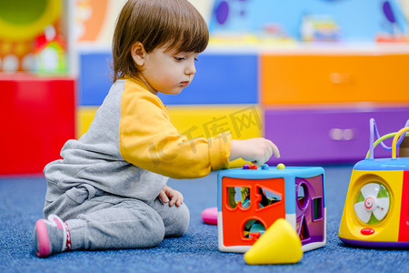 幼儿发育。小男孩在孩子们的房间里玩耍。一个孩子在幼儿发展中心玩耍.