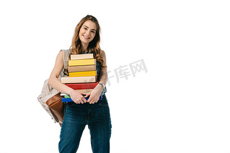 微笑的美丽的学生拿着一摞书籍孤立的白色