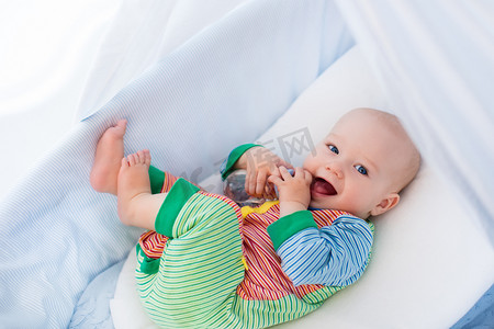 Little baby with bottle in white bed