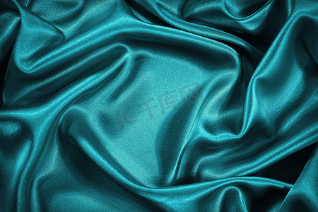 fabric摄影照片_ Beautiful blue green silk satin background. Wavy soft folds. Luxurious silky fabric backdrop with space for product and design. Web banner.                              
