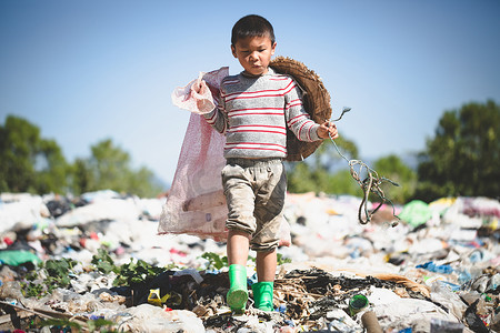 一个贫穷的男孩从郊外的垃圾填埋场收集垃圾，收集穷人的生活和生活方式，收集童工、贫穷和环境的概念
