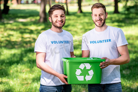 绿色回收箱的年轻男性志愿者