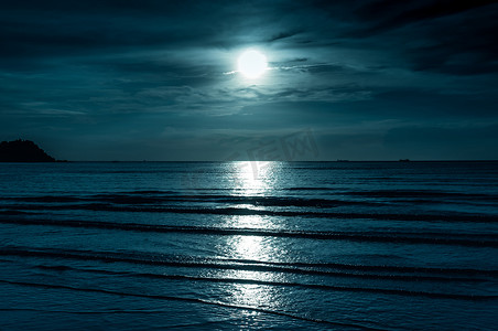 色彩斑斓的天空乌云密布，皎洁的月亮在海景。宁静自然背景.