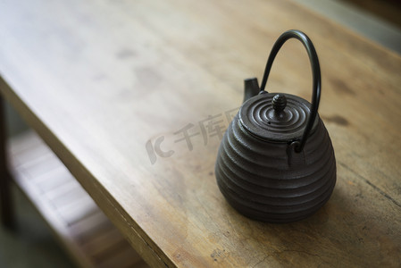 在木桌上的传统日本黑茶壶