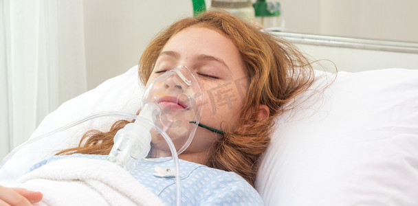 在医院里，带着氧气筒，在床上用氧气面罩吸气和治疗的可爱的亚洲小女孩。
