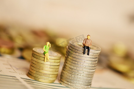 女性与男性收入或工资概念的差异，硬币堆栈上带有微型剪影