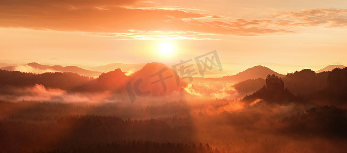 山丘背景摄影照片_在美丽的山丘的红雾破晓。山山峰都突出来了从雾背景，红色和橙色雾阳光下面.