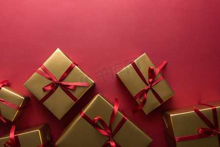 红色背景彩带金色礼品盒的顶视图