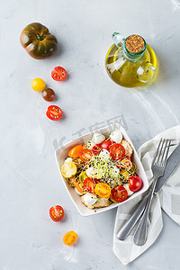 饮食、健康饮食的理念。厨房桌子上有各种有机樱桃西红柿、马苏雷拉奶酪、烤面包和微绿色。顶视图平面放置背景