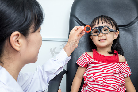 亚洲小中国女孩做眼睛检查由 ophthalmolog