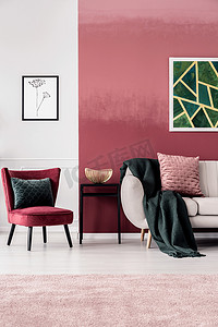 女性客厅内饰与勃艮第扶手椅和深绿色毯子上的米色沙发站在贝尔奥伯尔墙上