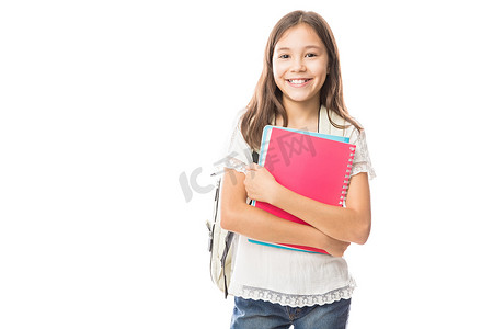 带书包的微笑女学生的肖像背上拿着书在白色背景下被隔绝