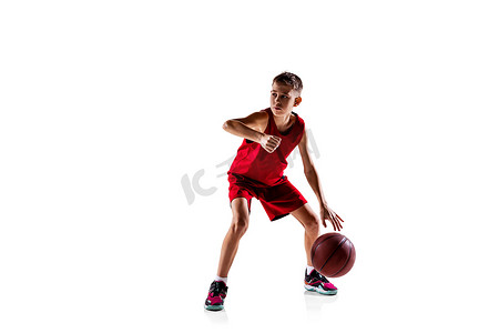 红色的篮球摄影照片_全长的男孩肖像，身穿红色制服训练的篮球运动员被隔离在白色背景之外。弹射传球