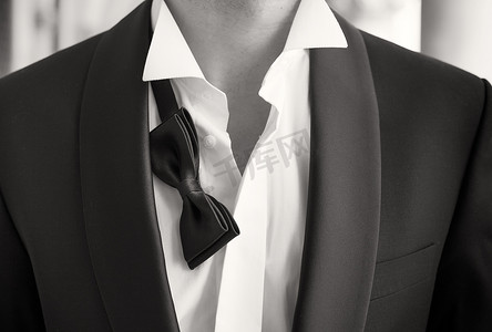 and摄影照片_Close-up photo of man in tuxedo with open shirt and loose bow tie