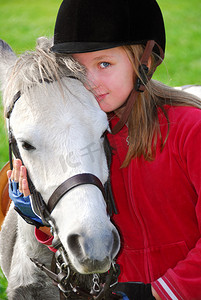 一个年轻的女孩和一只白色的小马的肖像