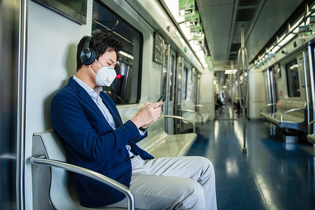 坐地铁戴口罩摄影照片_青年男子戴口罩乘坐地铁