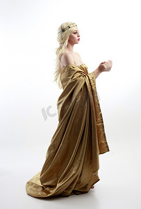 女神节买一送一摄影照片_ 身穿希腊女神托加礼服的漂亮女模特的全长肖像，在演播室背景上摆出优雅的姿势.