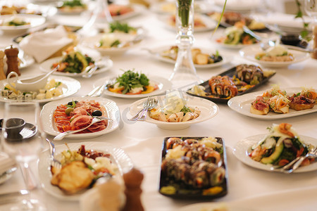 客人摄影照片_带混合食物的桌子。餐厅的宴会，餐桌设置。为客人提供不同的晚餐。新鲜食品
