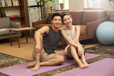健康瘦身摄影照片_青年夫妇在家健身中场休息