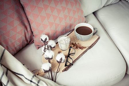 秋天舒适的早餐。浪漫的早餐棉花, 一杯热咖啡, 一支蜡烛, 一块格子, 一副眼镜。秋季舒适。一个托盘
