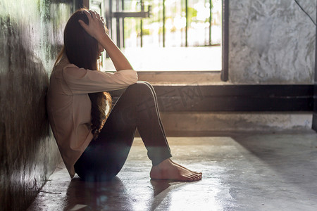 年轻有压力的女人坐在房间里, 伤心沮丧的女性.