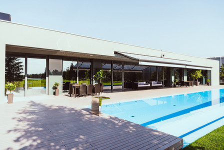 美丽的现代小屋与室外游泳池在晴朗的蓝天之下