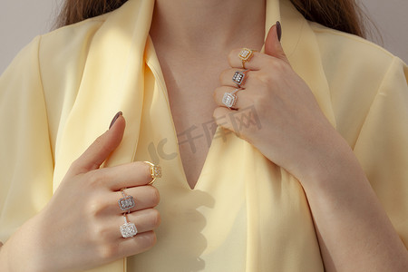 Multiple diamond rings on attractive female model. The model is displaying multiple wedding rings on her fingers.