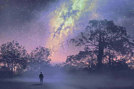 男人站在反对银河之上映衬树