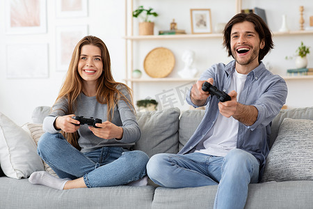 情绪激动的年轻家庭在客厅玩电子游戏