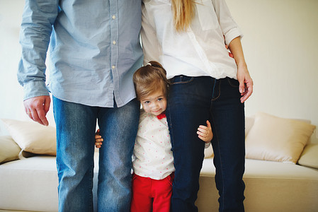 女孩抱着爸爸和妈妈的双腿