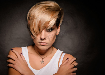 Girl with a short stylish haircut on a dark background