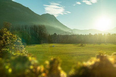 蓝天绿地背景摄影照片_奥地利，一个阳光明媚的蓝天背景下，美丽的乡村风景，绿地繁茂，草木朦胧.