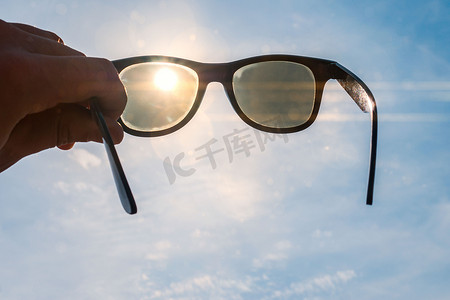 太阳镜在一只手在海滩上, 明亮的夏天天