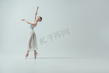 舞蹈工作室摄影照片_迷人的芭蕾舞演员在白色的礼服舞蹈工作室, 孤立的白色