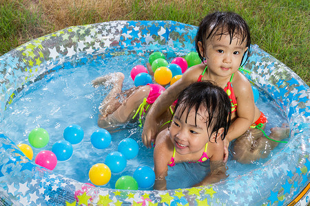 亚洲小中国女孩玩，在橡胶充气游泳