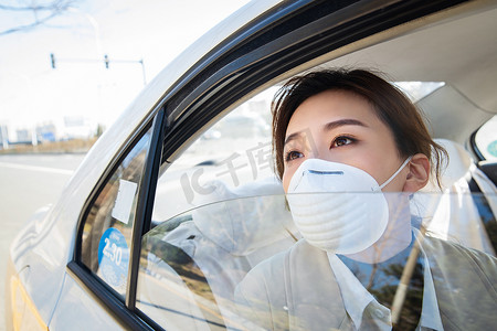 年轻女人戴口罩乘坐汽车