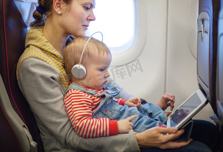 母亲和儿子使用平板电脑的但船上的飞机