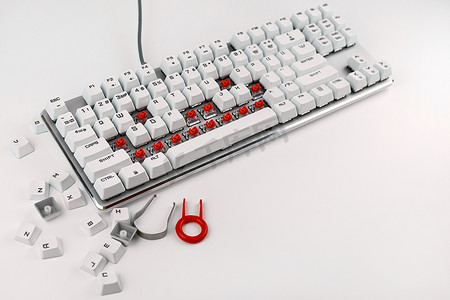在白色背景上拆开键盘.拆卸和清理计算机键盘.清洗电脑设备。机械键盘开关.