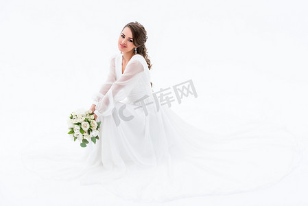微笑的新娘在优雅的礼服举行婚礼花束, 孤立的白色