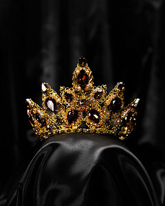 在黑色的背景上，一个发饰，一个镶有红宝石的皇冠，一个权力和美丽的象征