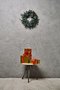 金色圣诞礼品盒, 红色丝带在椅子下的杉木花圈在房间里