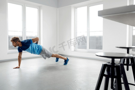 健身运动男摄影照片_人锻炼锻炼。健身 男模特在室内做俯卧撑