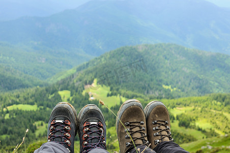 旅行者坐在高山顶上的登山靴