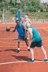多种族老年人在操场上打篮球在夏天天